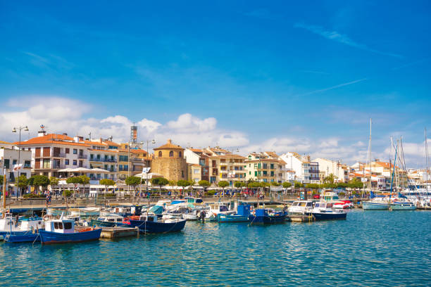CAMBRILS, SPAIN - APRIL 30, 2017: View of port and city waterfront with Church Of Saint Peter in middle and Torre del Port. Copy space for text.